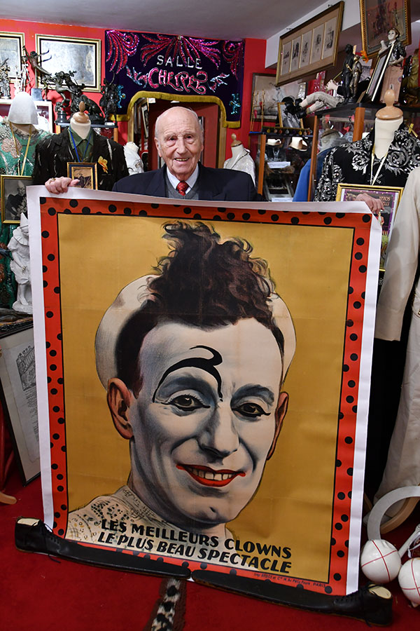 Alain Frère posant avec une affiche donnée par Serge Gambi © Musée du cirque